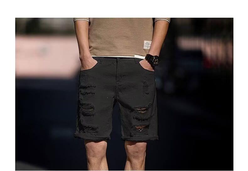 short en denim noir délavé, avec genoux déchirés et un aspect décontracté légèrement porté, adapté à la mode streetwear
