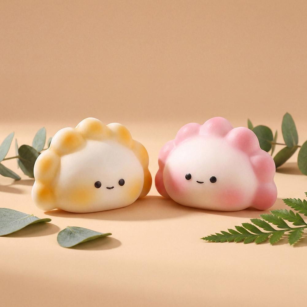 dos adorables squishies con forma de dimsum para aliviar el estrés, en tonos pastel suaves de amarillo y rosa, con lindas caritas sonrientes, diseñados para juguetear y aliviar el estrés