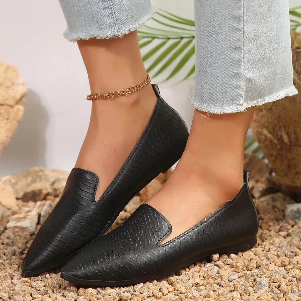 Mocasines de cuero negro con textura de piel de serpiente y diseño de punta afilada, con diseño elegante, tipo mocasines planos para poner y quitar con facilidad.