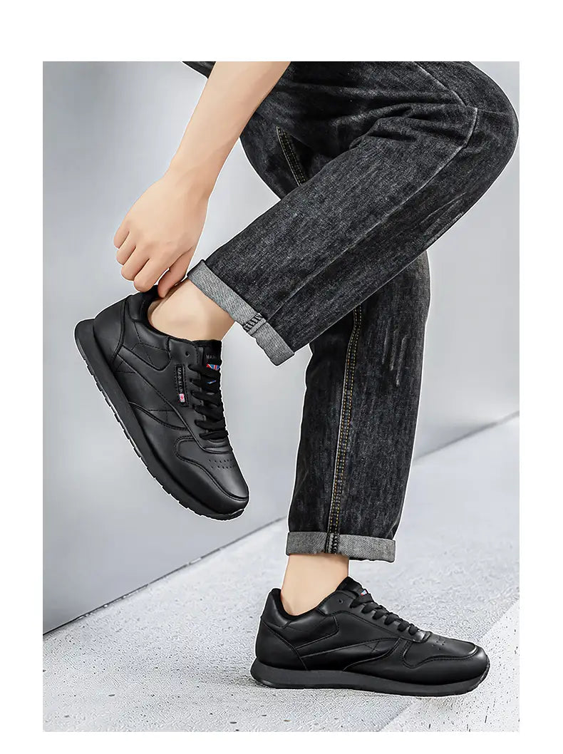 Schwarze Ledersneaker für Herren mit elegantem, minimalistischem Design und dezenten Markenzeichen, geeignet für Freizeit und Sport