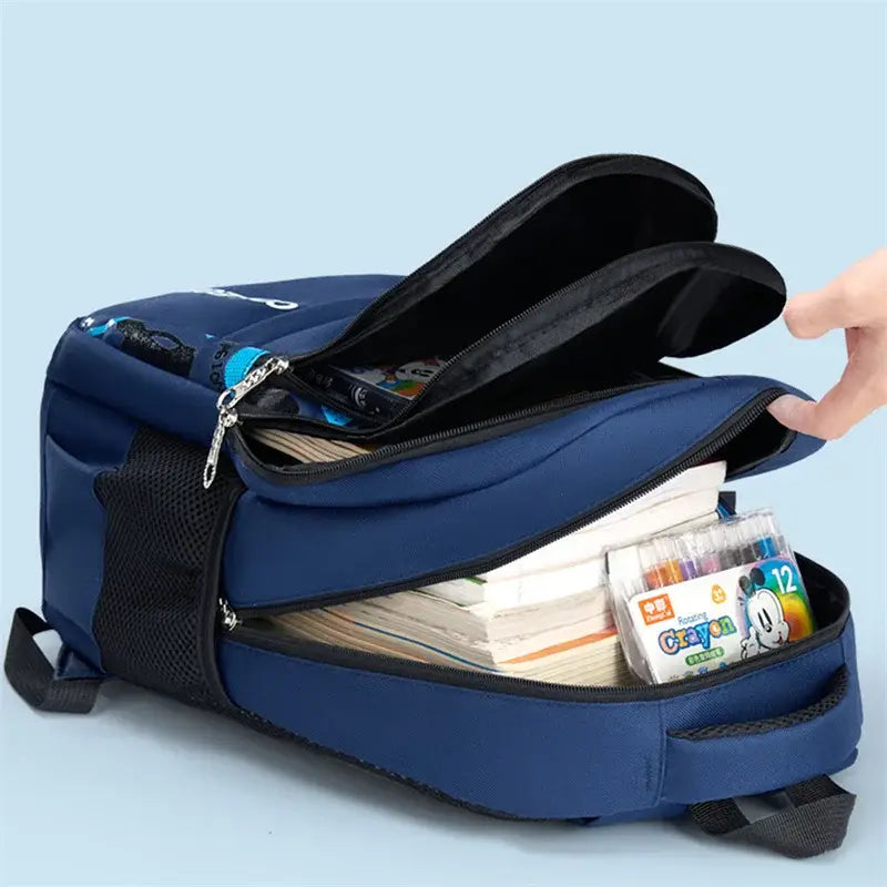 Navyblauer Jungen-Wasserschulrucksack mit schwarzen Reißverschlüssen und seitlichen Netztaschen, gefüllt mit Büchern und farbigen Markern.