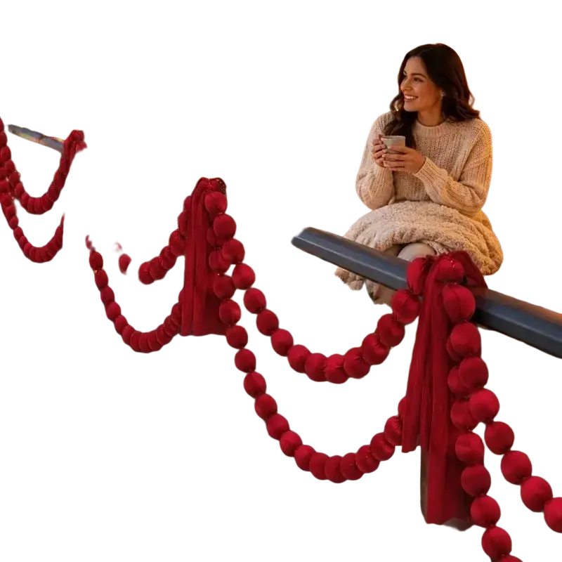 Red pom-pom ball garland draped along balcony railing for christmas decoration in burgundy velvet fabric