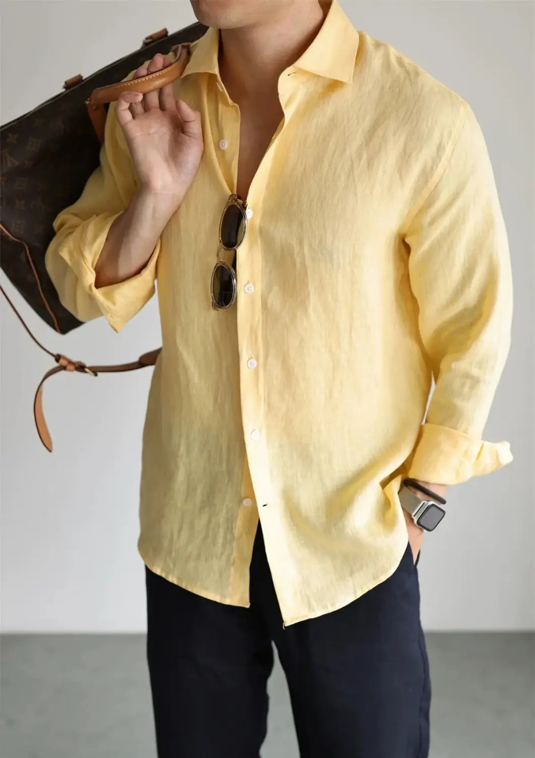 A pale yellow men cotton linen casual button down shirt featuring a classic collar and rolled-up sleeves.