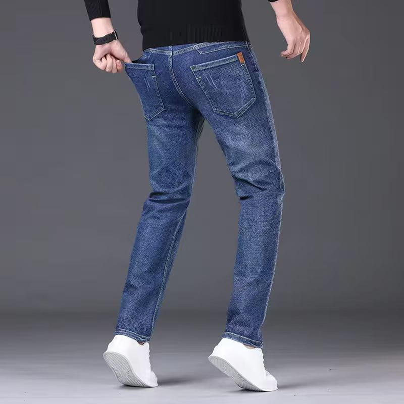Mens stretch denim jeans slim fit casual pants in blue with subtle fading showing the back side featuring classic pockets and a brown leather brand patch.