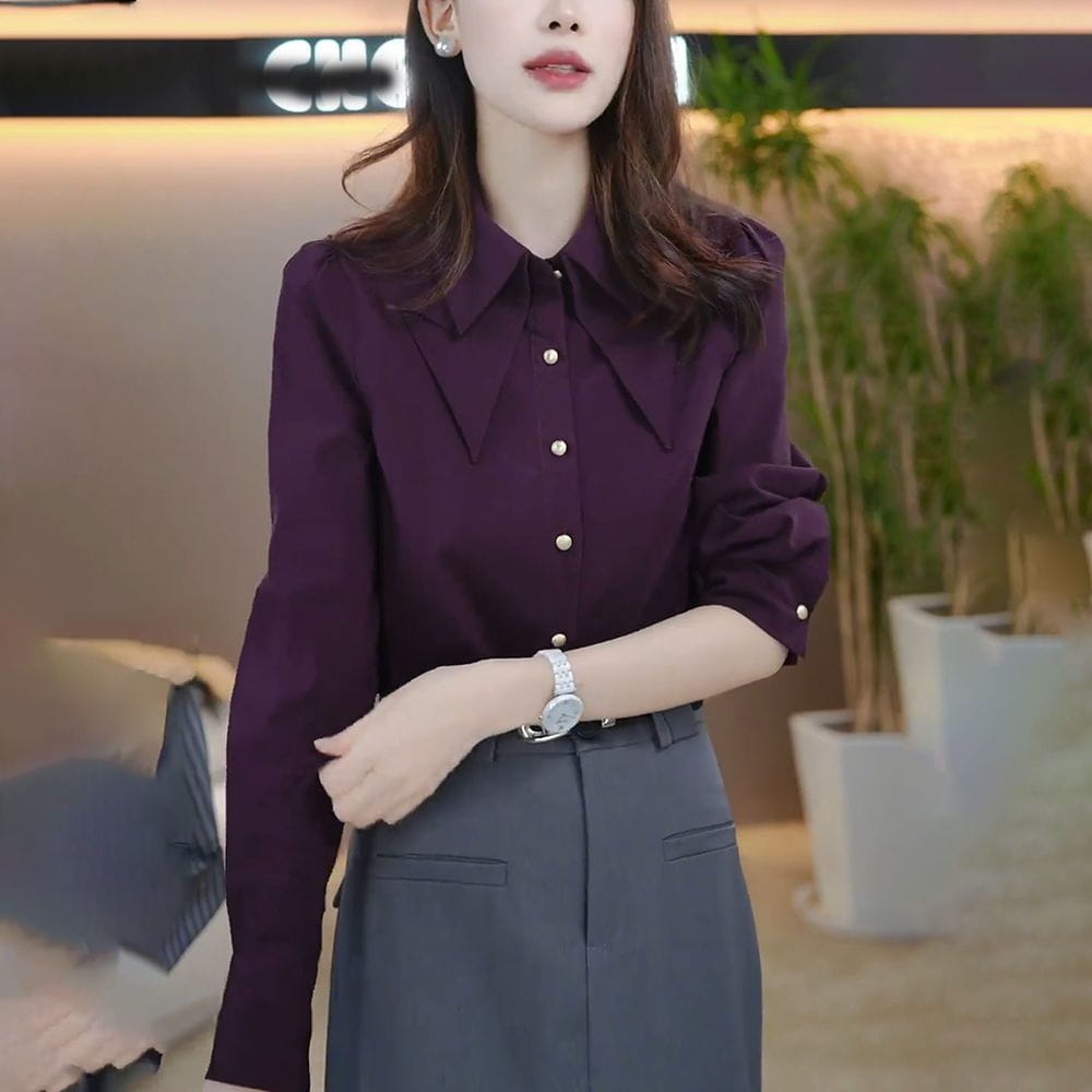 A deep purple satin blouse with long sleeves, a classic collar, and pearl-like buttons featuring modname=ckeditor.
