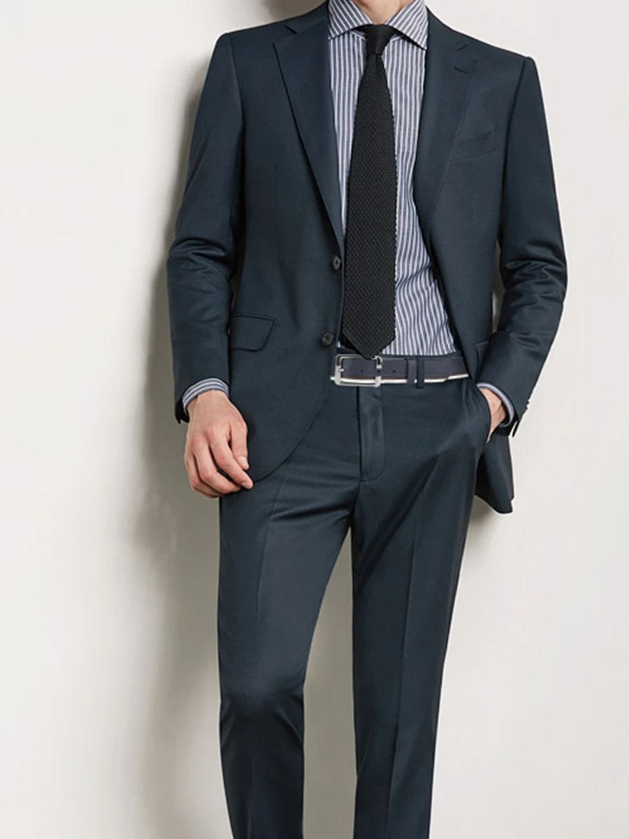 Dark navy suit with a tailored fit featuring subtle sheen and structured lapels paired with a men leather belt with a white braided contrast stripe.