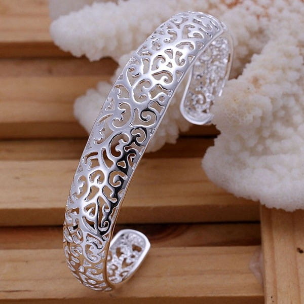 Sterling silver filigree cuff bracelet featuring intricate swirling patterns in an open design.