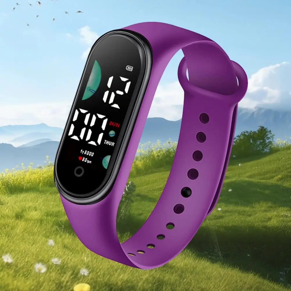 Reloj electrónico de silicona morada con pantalla de letra grande y visualización digital negra que muestra la hora, la fecha y el conteo de pasos, diseñado para uso deportivo.