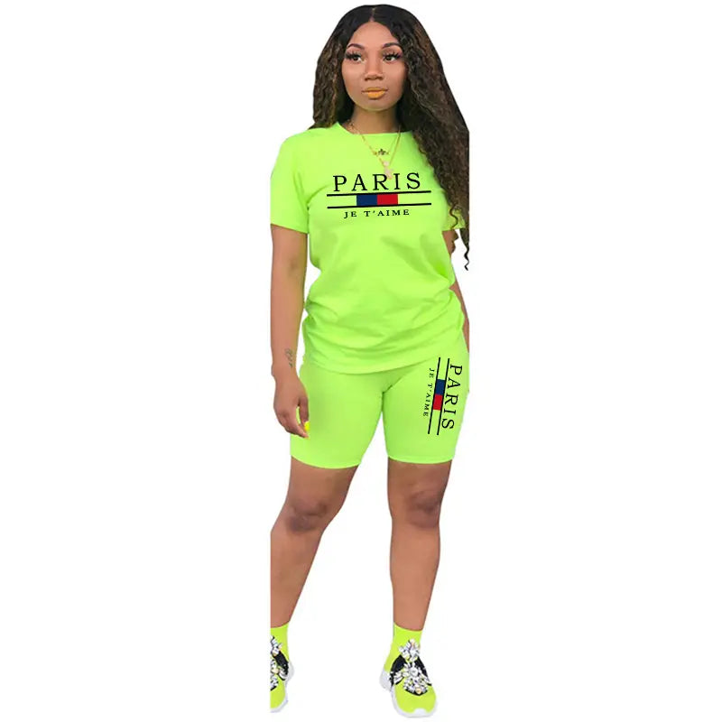 Ensemble deux pièces pour femmes en vert fluo : haut à enfiler avec fermeture et short, comprenant un design « Paris je t’aime » pour un usage sportif.