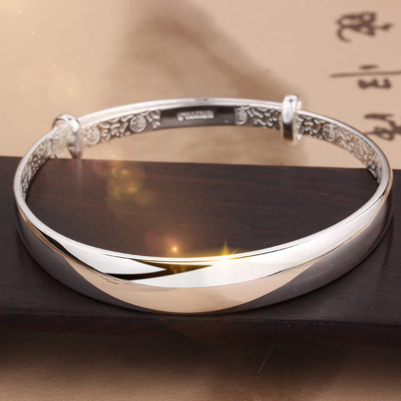 Sterling silver round bangle bracelet for women featuring intricate engraved patterns and a smooth polished finish.