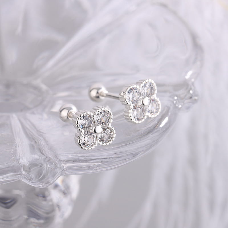 Pendientes tipo clavo con trébol de cuatro hojas en plata de ley adornados con cristales transparentes, con un diseño de flor de cuatro piedras.