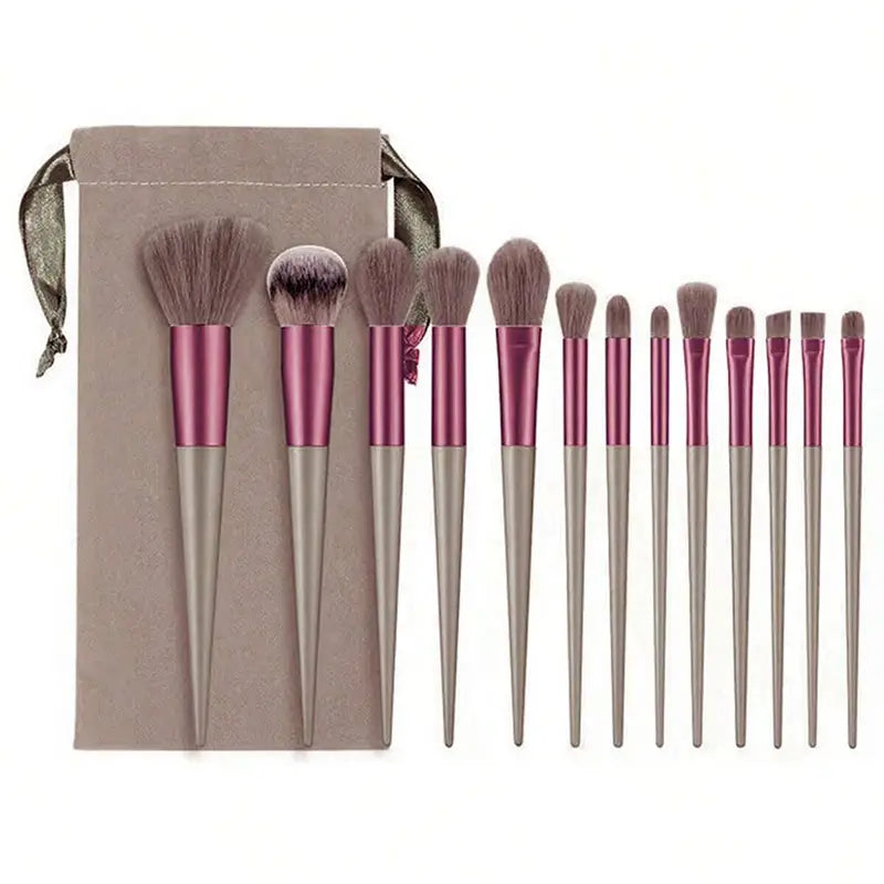 Set aus 12 professionellen Make-up-Pinseln mit roségoldenen und silbernen Griffen sowie weichen, unterschiedlich großen Borsten, angeordnet neben einem passenden taupefarbenen Samtbeutel in einem 13-teiligen Make-up-Pinselset.