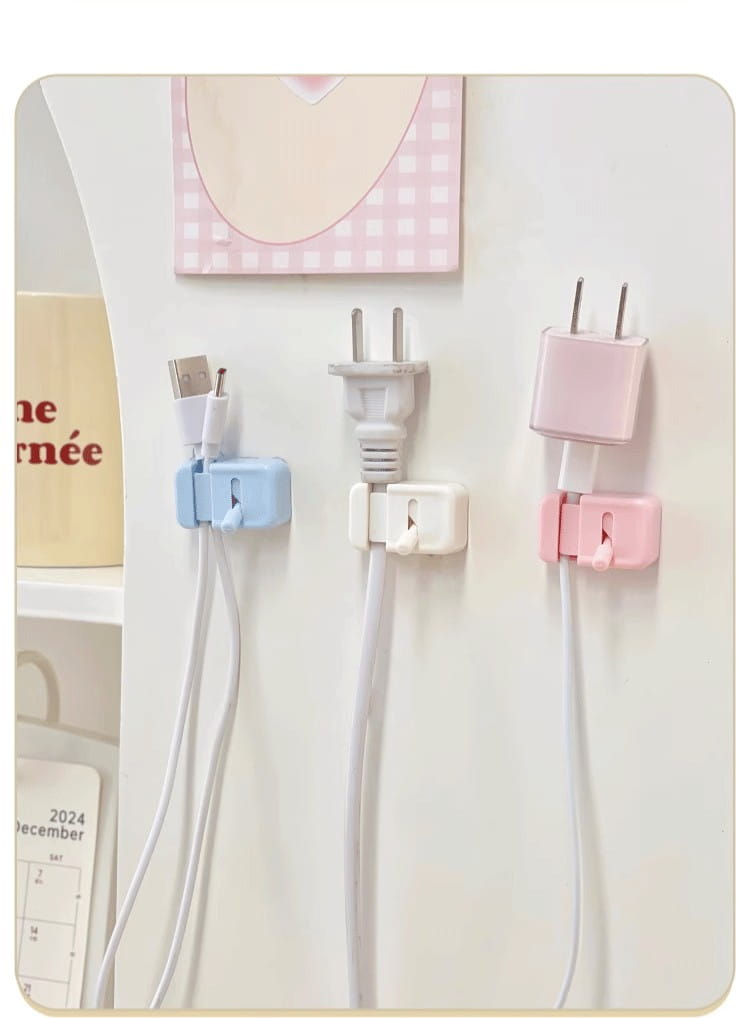 Trois pinces de câbles pour bureau murales en plastique aux couleurs pastel, organisateurs de cordons sans perçage, chacune maintenant un type différent de prise et de cordon