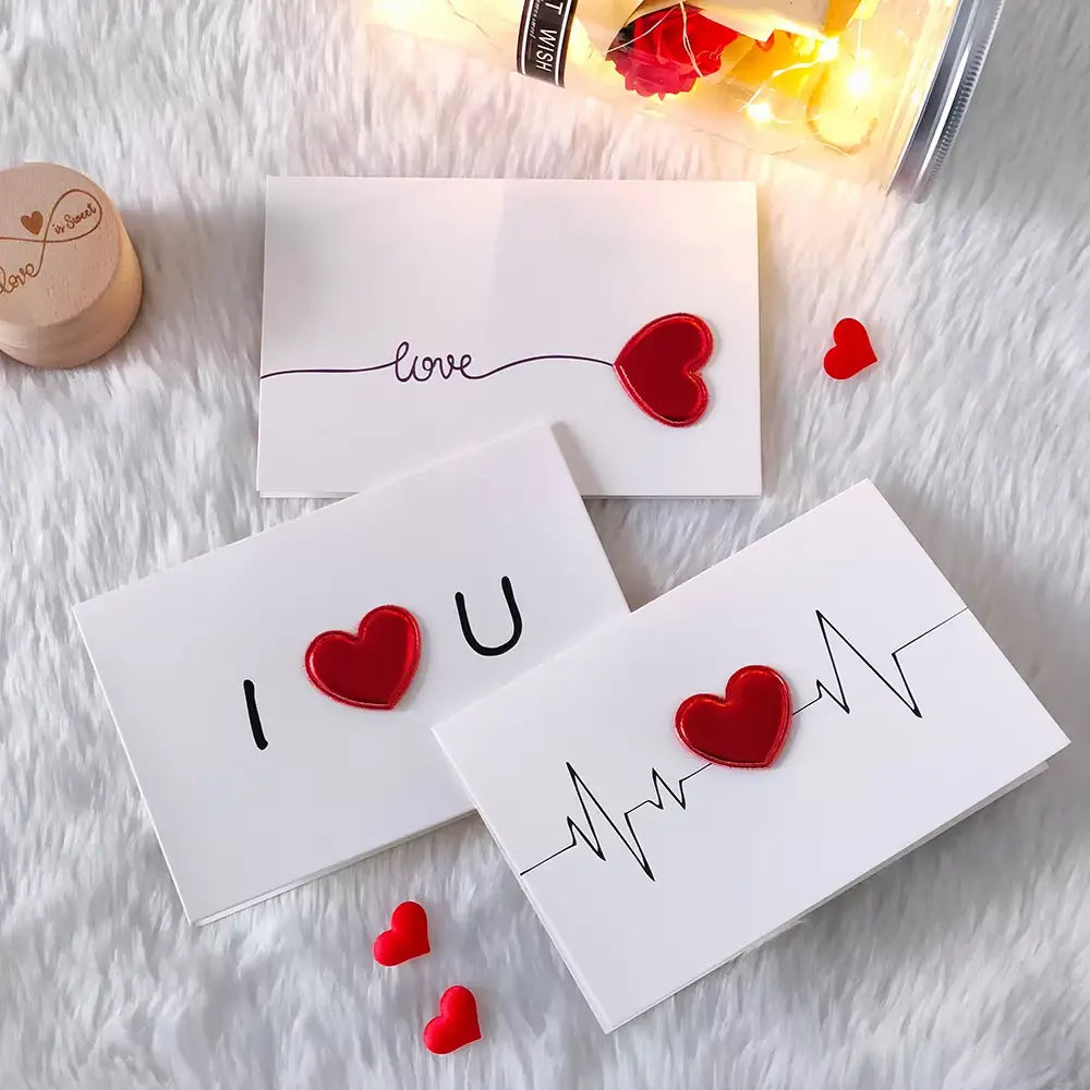 White Valentine heart greeting cards with red heart embellishments and black handwritten-style text for wedding invitations.