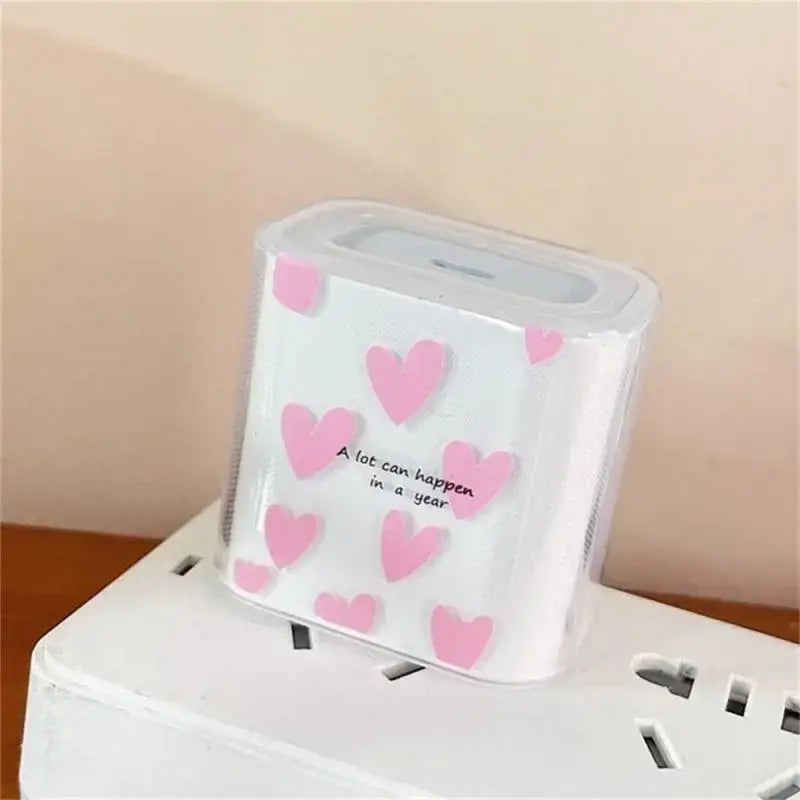 white iphone charger protector 4pack tpu wrap featuring a clear protective plastic case with pink heart decals and the phrase a lot can happen in a year printed on it