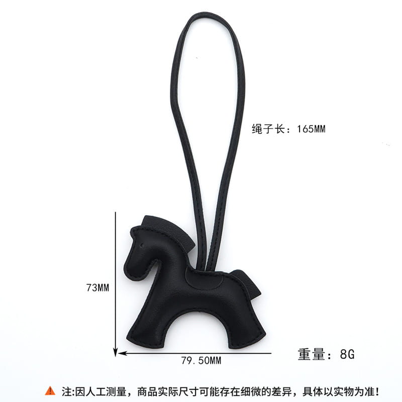 Porte-clés en cuir noir en forme de cheval avec lanière bouclée, mettant en valeur le côté avant du design