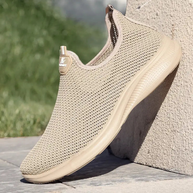 Baskets décontractées pour hommes à enfiler en mesh respirant de couleur beige, avec col rembourré et semelle en caoutchouc.