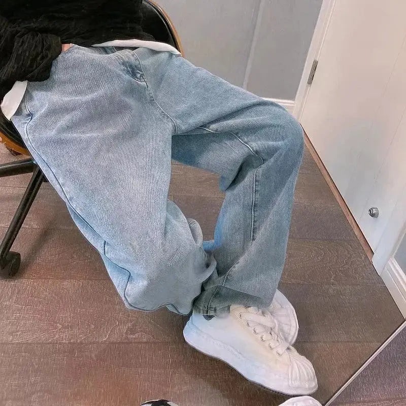 Pantalon cargo en jean à jambes larges à effet délavé clair avec broderie croisée noire, à coupe décontractée à jambes larges.