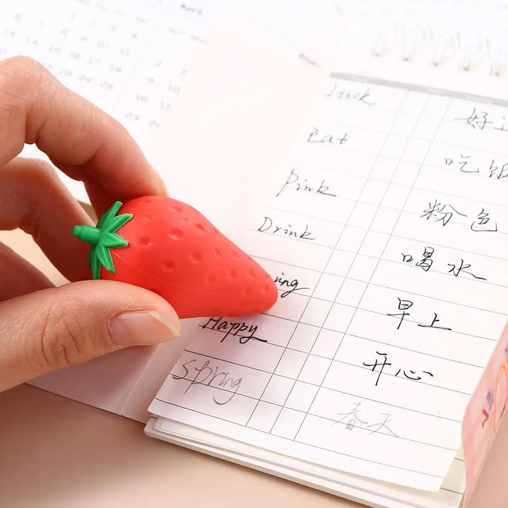 Red strawberry-shaped eraser with green leafy top from the fruit pencil erasers cute student stationery set, designed for erasing pencil marks.