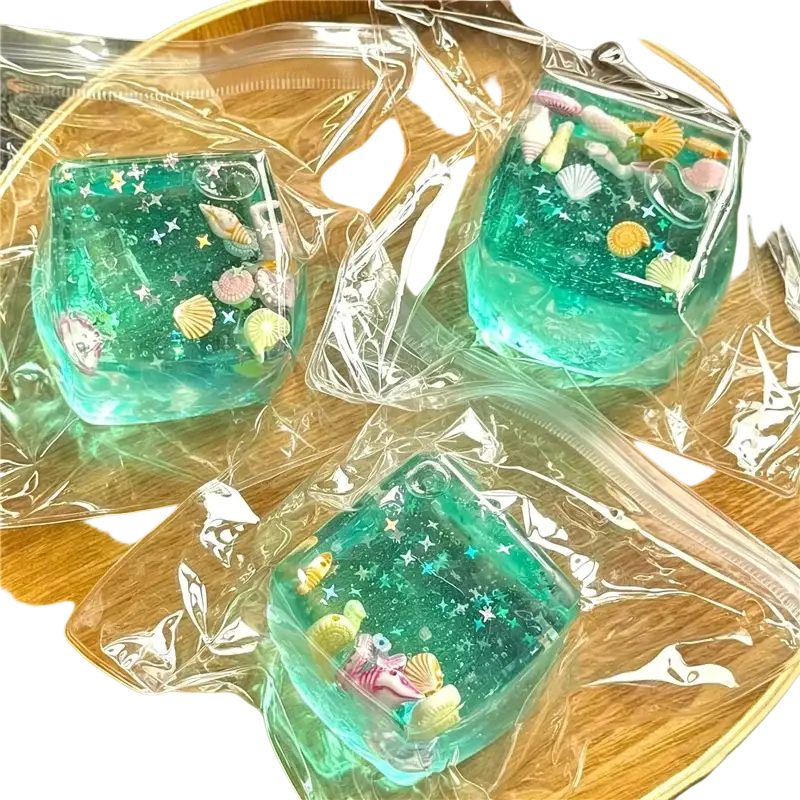 Translucent teal resin swim ocean maltose squishy cube with seashells star glitter and fish figurines viewed from front