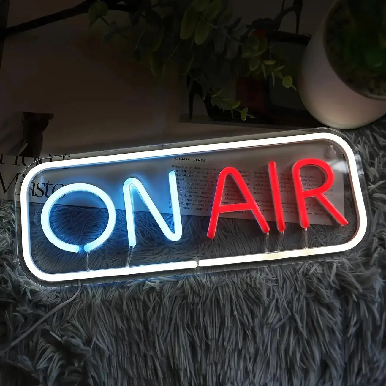 Enseigne néon LED « On Air » art mural USB, présentant une enseigne néon lumineuse avec « on » en bleu et « air » en rouge, insérée dans un cadre blanc élégant.
