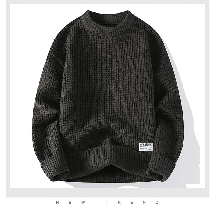 Moownuc Herren-Waffelstrick-Pullover im lässigen Stil in Dunkelgrau mit geripptem Strick, Rundhalsausschnitt und strukturiertem Muster; mit einem kleinen weißen Label auf dem unteren linken Ärmel.