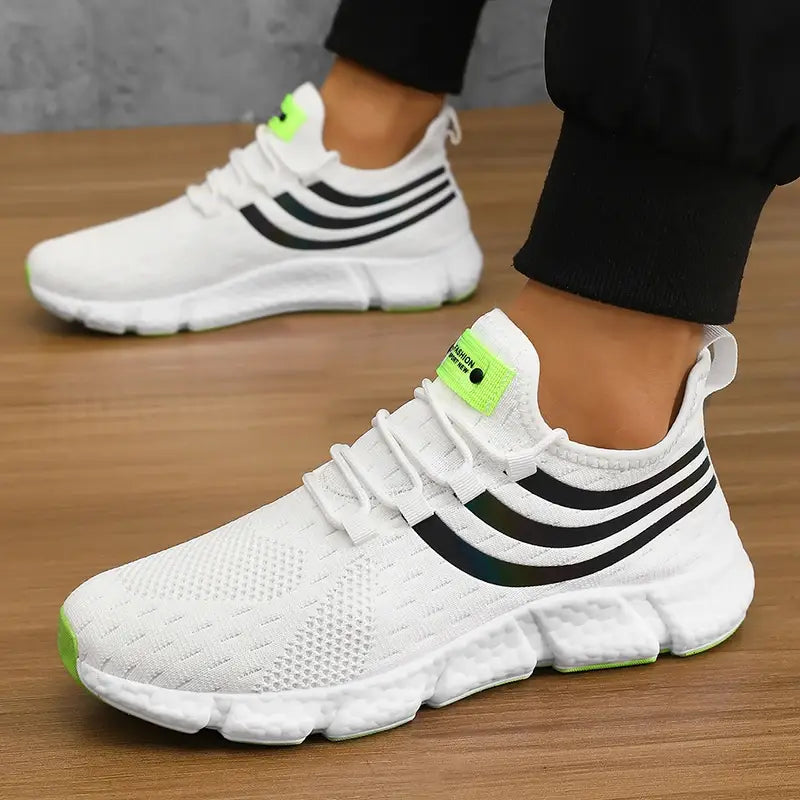 Baskets de sport décontractées en maille respirante pour hommes Zuuban en mesh blanc, avec trois bandes noires et des accents vert néon sur la semelle et la languette.