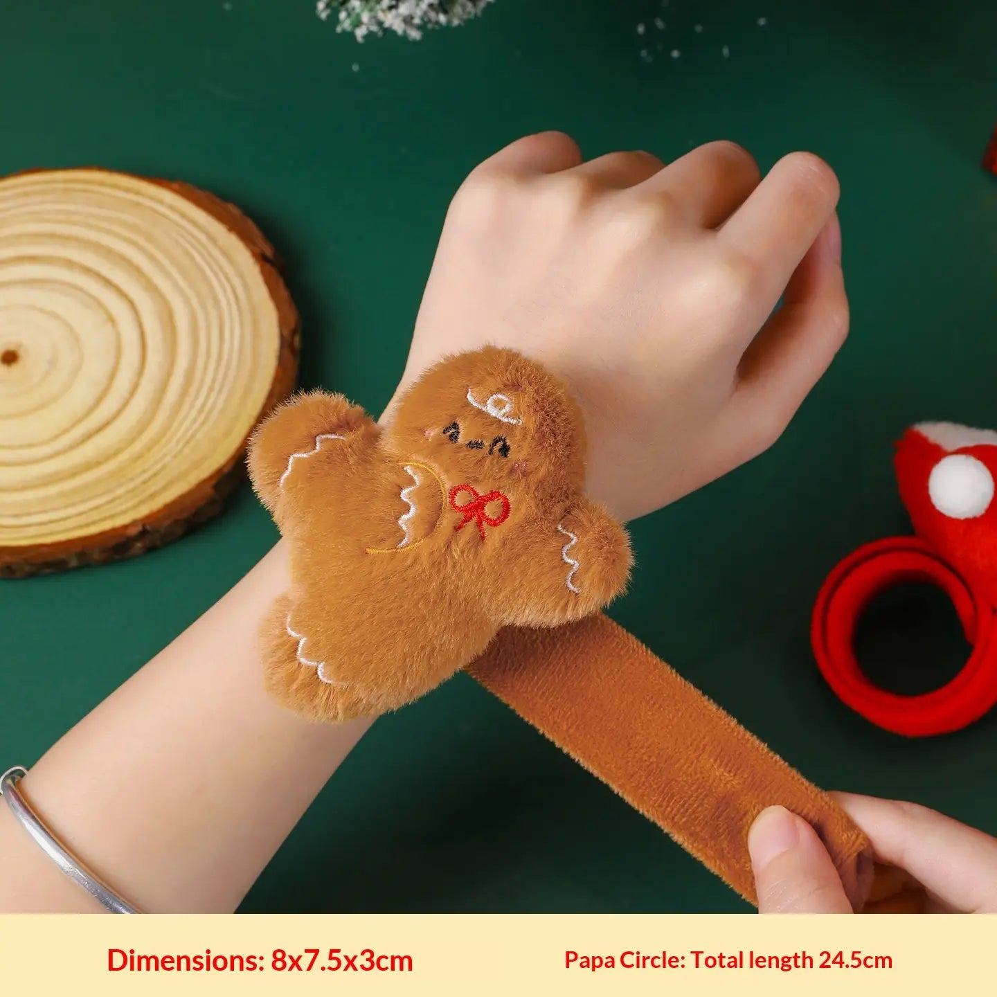 Pulsera tipo eslogan esponjosa marrón suave con forma de hombre de jengibre para niños, con rasgos faciales bordados y un lazo rojo.