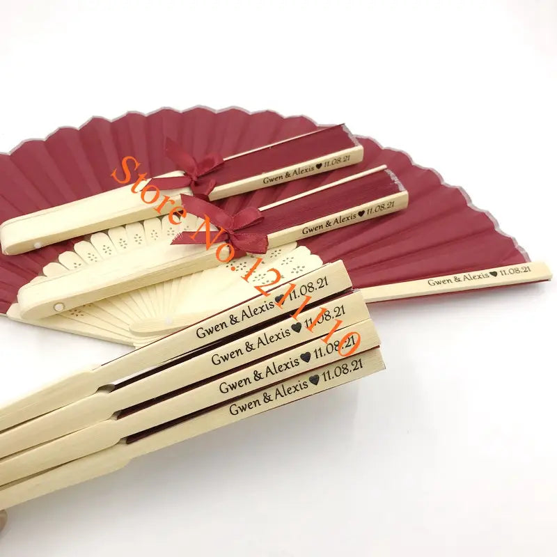 beige wooden folding fans with maroon ribbons and engraved names made of bamboo and silk custom wedding hand fans personalized favors
