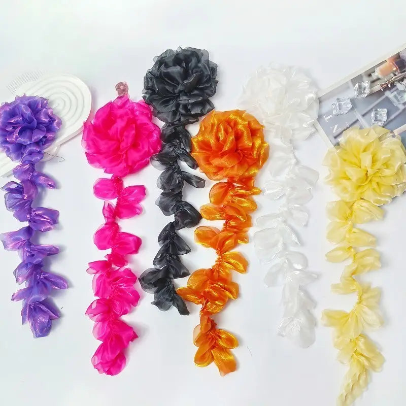 紫、ピンク、黒、オレンジ、白、黄のカラフルなフリル生地のフラワーチェーンをあしらったオーガンジーの花タッセル・ブローチピンのコレクション。