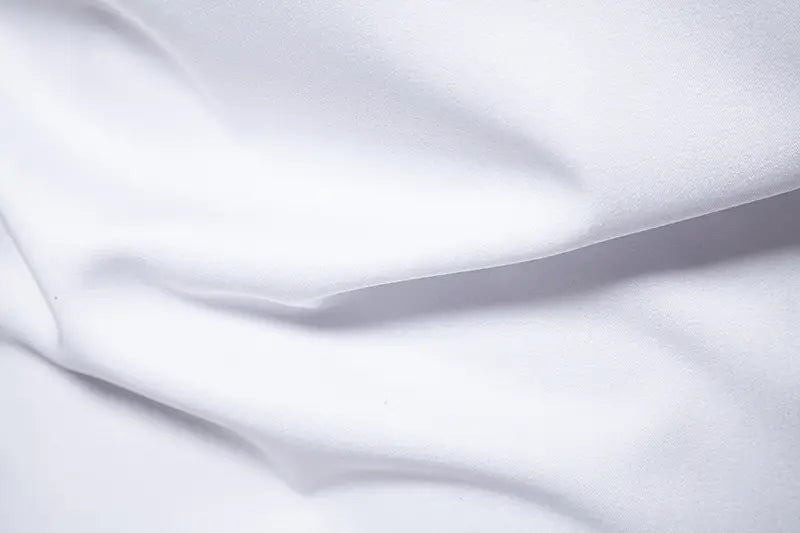 men asymmetrical slant collar long sleeve casual shirt made of soft white satin fabric with gentle folds and a smooth flowing texture