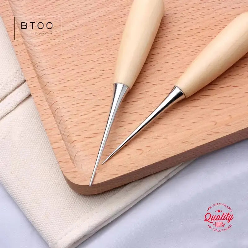 Two btoo brand leather hole punch beading awl tools with light-colored wooden handles and shiny steel tips for precise leather crafting.