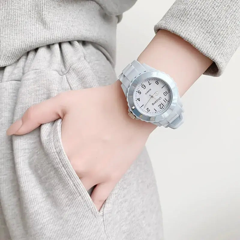 A kids silicone quartz watch with a light gray silicone strap, white dial, silver-toned bezel, and black arabic numerals.