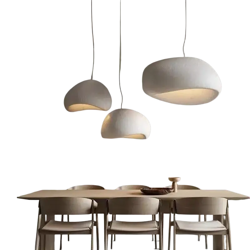 Three off-white organic cloud-shaped pendant lights hanging above a dining table in a living room and dining room setting