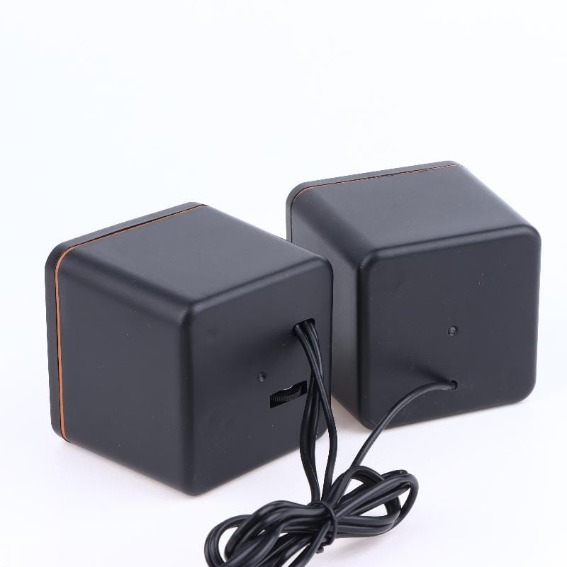 USB-Computerspeaker mit Mikrofon mit schwarzer würfelförmiger matter Oberfläche und dezent kupferfarbener Zierleiste entlang der Kanten.