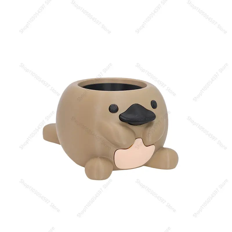 Encantadora maceta de suculentas de plástico color beige con forma de pingüino platino, pico negro y panza rosa, diseñada para uso en escritorio.