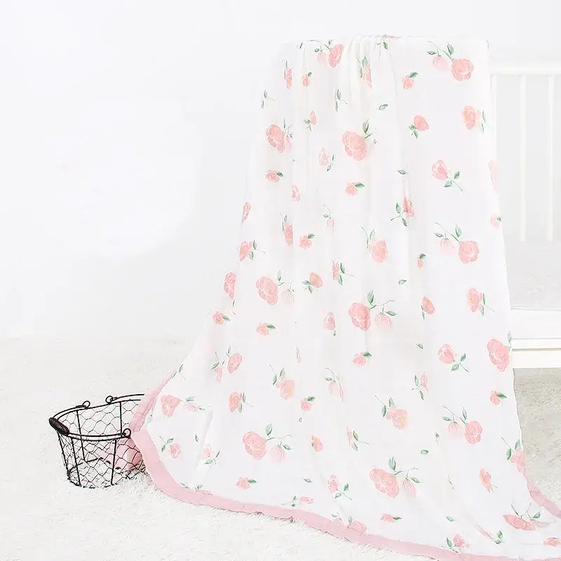 Eine zarte weiße Bambus-Baumwoll-Decke für Babys (Swaddle) mit sanften rosafarbenen Rosenprints und einem passendem rosa Saum.