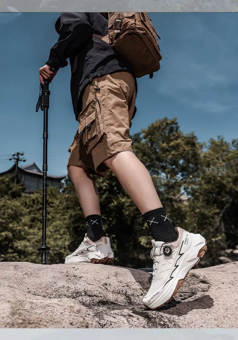 Men hiking shoes waterproof lightweight trekking sneakers white chunky athletic sneakers with black lightning bolt detailing and a brown sole.