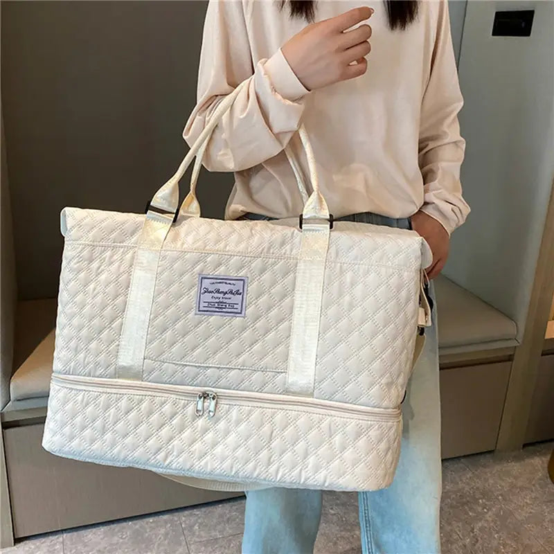 Bolsa de viaje tipo duffel acolchada tote weekender grande color crema, con asas resistentes y compartimento frontal con cierre.