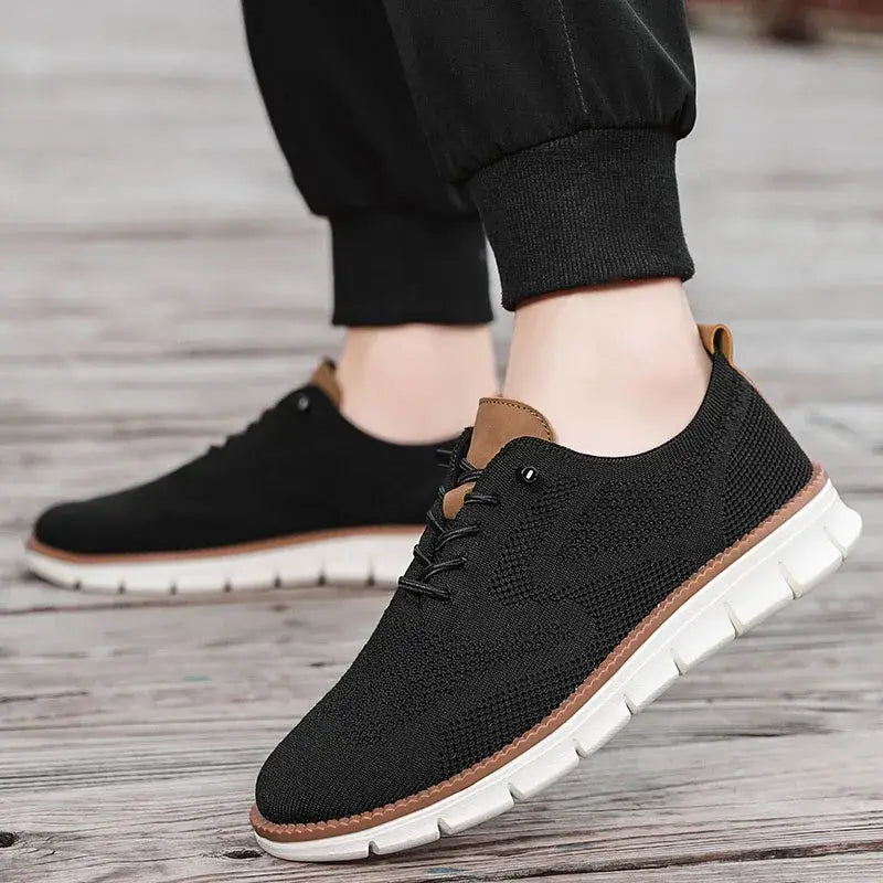 Chaussures derby brogue décontractées en maille pour hommes, de couleur noire, avec des accents tan et une semelle en caoutchouc blanc.