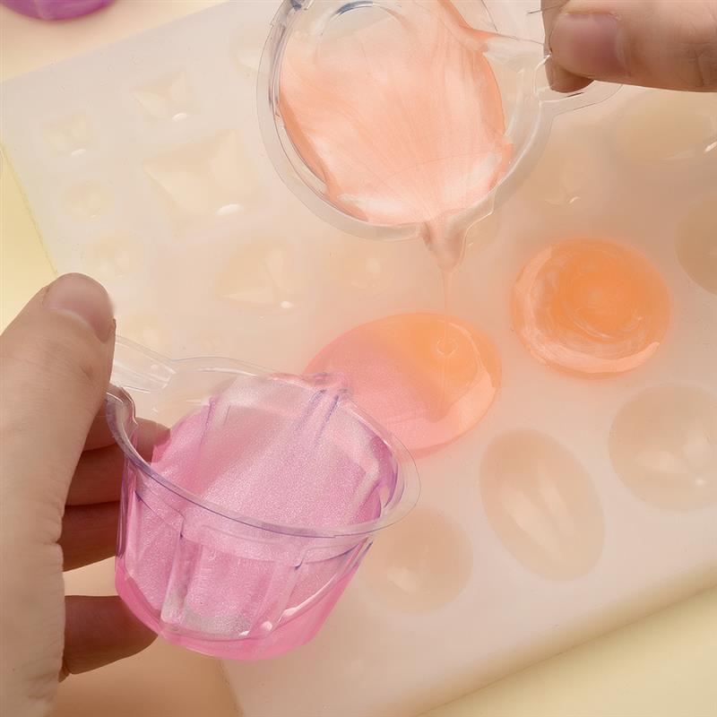 pink glittery resin pouring into a clear silicone mold with fluted edges in an epoxy resin mixing tool set for diy jewelry making
