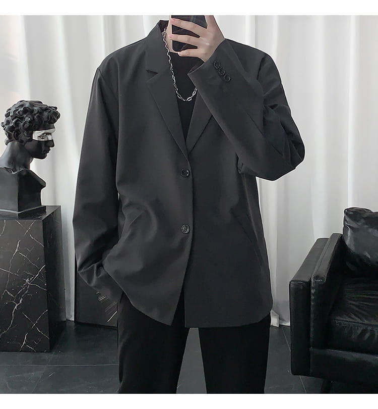 Schwarzer übergroßer Blazer mit legerer Passform und Dreiknopf-Verschluss, gestaltet als Herren-Casual-Loose-Blazerjacke in einfarbigem Stil.
