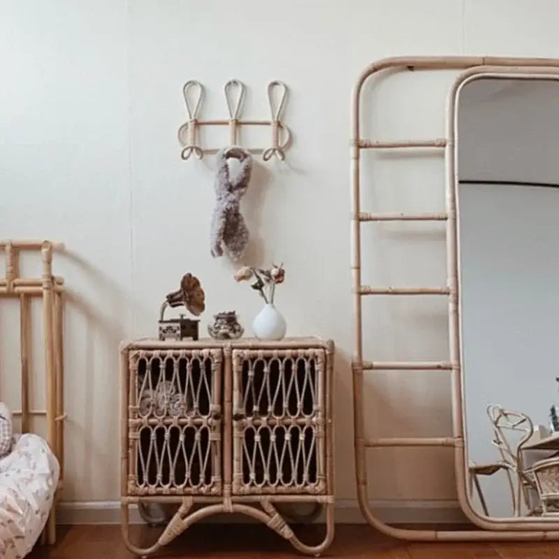 Rattan-Kinder-Wandhaken mit Garderobenständer zur Aufbewahrung von Kleidung, mit Rattan-Schrank und geflochtenen Türfüllungen sowie naturbeiger Ausführung.