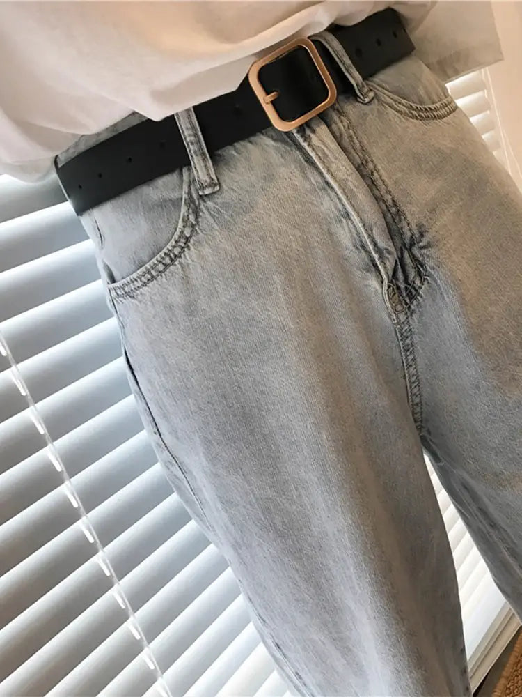 Women leather belt casual fashion waist strap in black featuring a gold-toned square buckle paired with light-wash denim jeans.