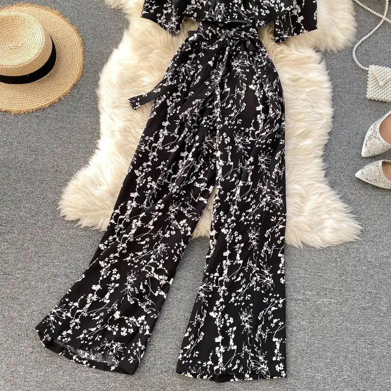 Enterizo de pierna ancha con estampado floral blanco y negro, con cinturilla atada y diseño con escote tipo bardot.