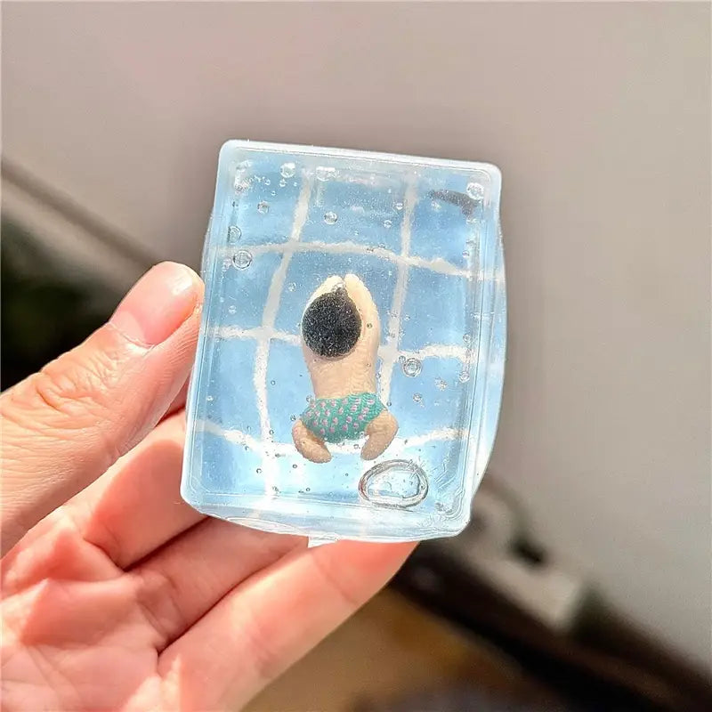 un cube sphérique océan à faible rebond, visqueux et lent, en gel bleu transparent, avec une petite figurine de chien portant des shorts de bain verts, suspendue à l’intérieur
