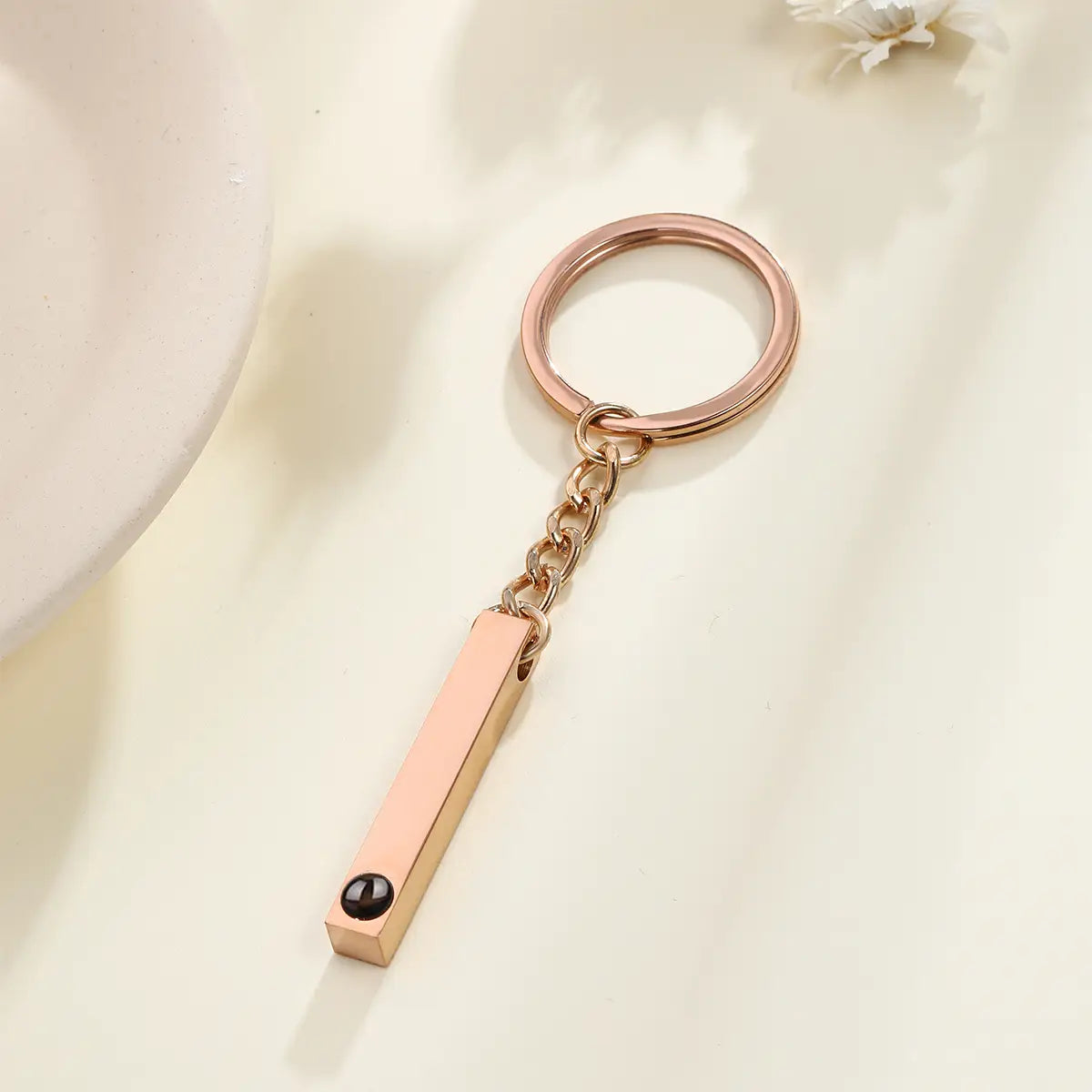 Rose gold rectangular bar custom photo projection keychain with a black spherical accent personalized as a memorial gift.