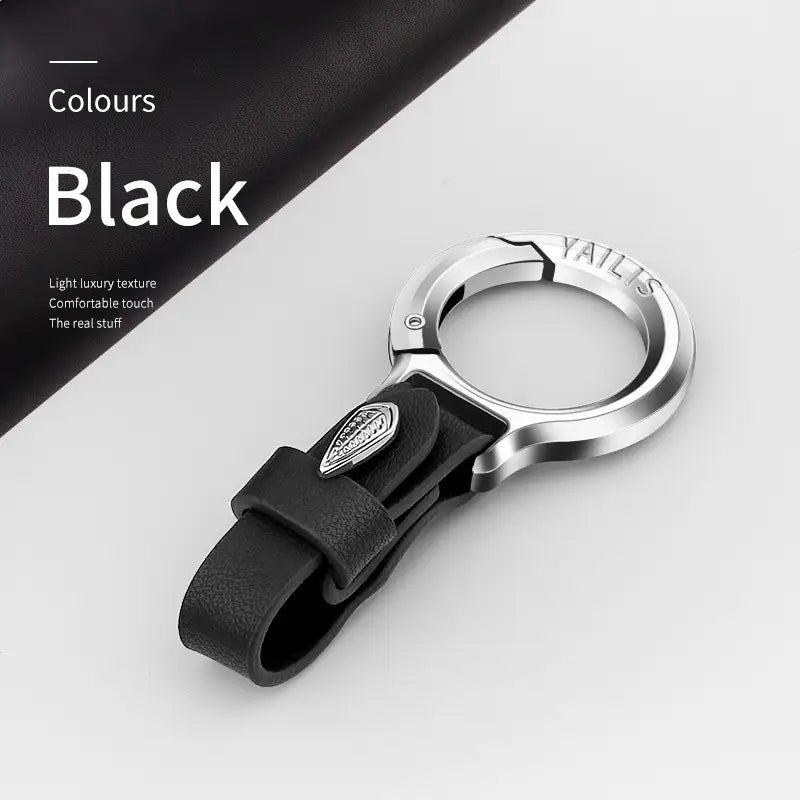 Black leather car keychain with silver-toned metal loop and small leaf charm on the strap