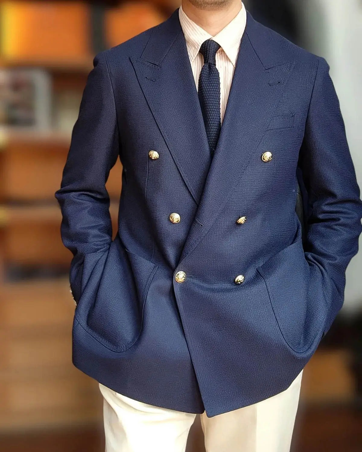 Veste de smoking bleu marine à double boutonnage avec boutons ton or et tissage légèrement texturé, dotée d’un type de fermeture à double boutonnage, conçue pour la tenue du marié.