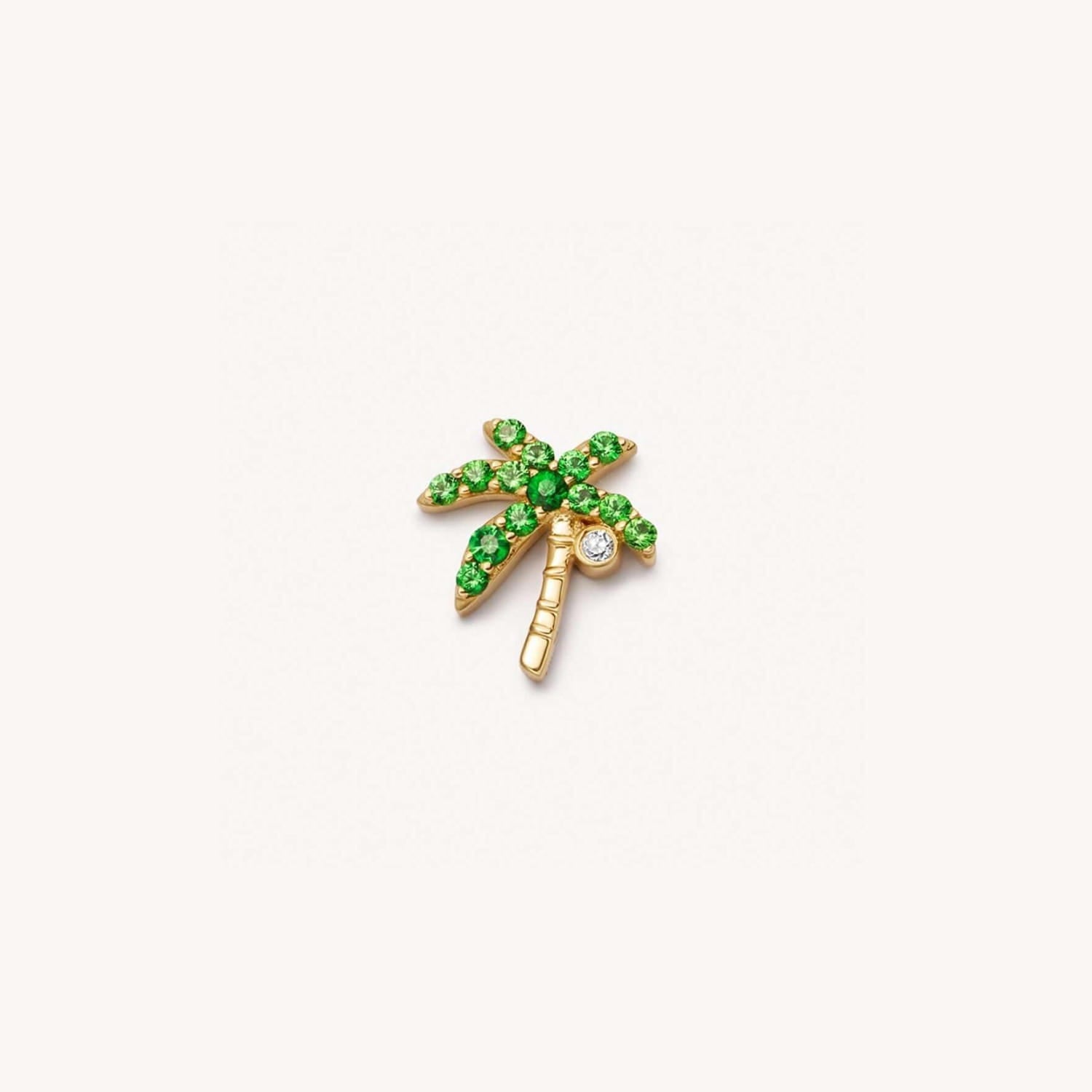 boucle d’oreille délicate en ton or en forme de palmier, avec des pierres précieuses vert vif et des détails clairs façon diamant, complétant les styles pour femmes et jeunes filles, le style vestimentaire simple et les colliers pendentifs ouverts.